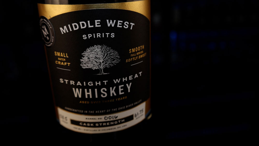 A bottle of Middle West Spirits' Cask Strength Wheat Whiskey with a close up of the label.